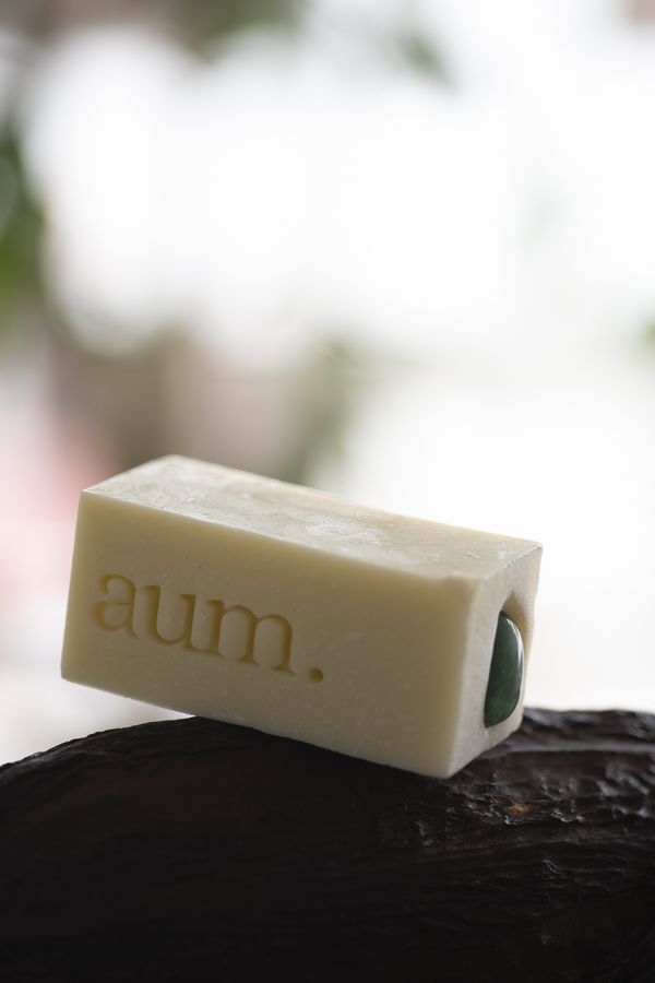 Jabón de Aventurina aum. inclinado sobre roca oscura con cápsula seca de physalis